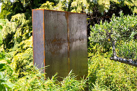 Sichtschutzwand aus Cortenstahl in einer Bambuspflanzung in einem Ptivatgarten.