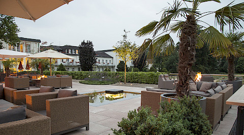 Gastronomieterrasse mit großformatigen Betonplatten und Teich in Bad Lippspringe.